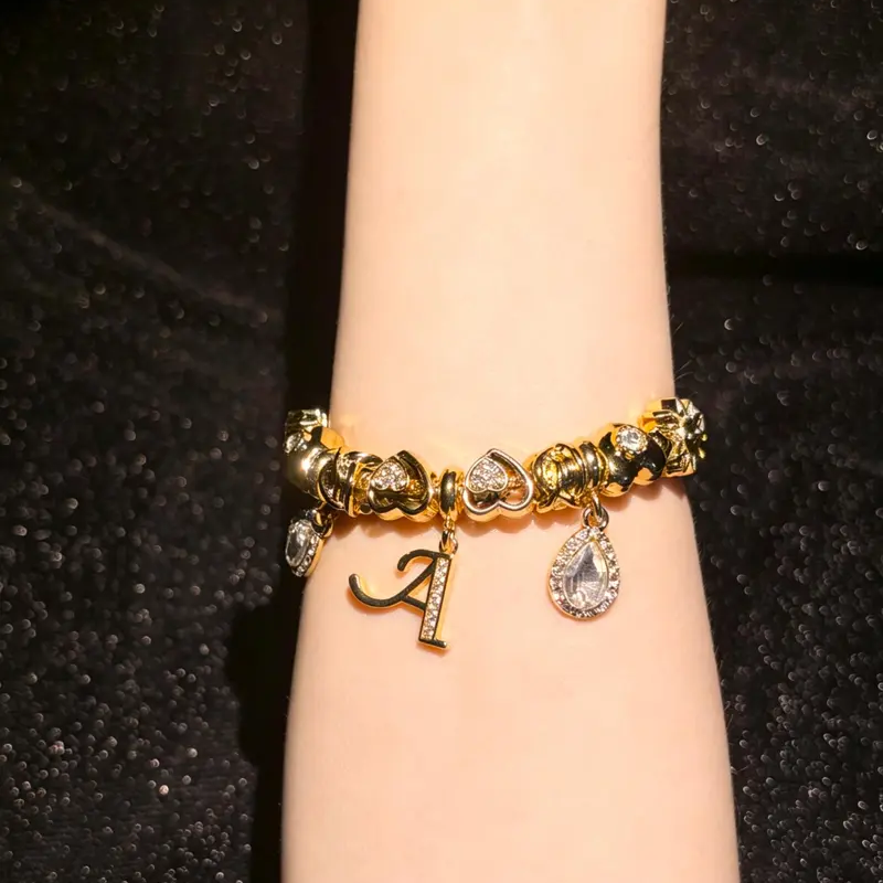 Initial charm bracelet worn on wrist